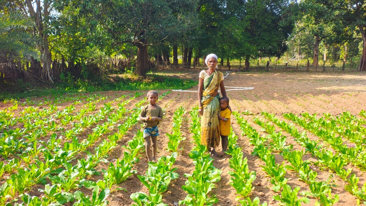 Sanbati from Hasel village in her field along with her children 
